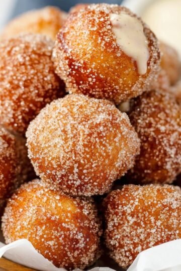 The Best Cinnamon Sugar Soft Pretzel Bites 18 A pile of golden-brown cinnamon sugar soft pretzel bites, freshly coated and ready to be enjoyed with a creamy dipping sauce.