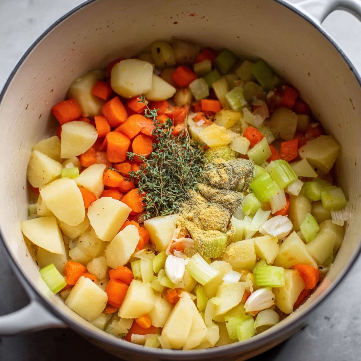 Easy Creamy Vegetable Soup Recipe 11 Chopped potatoes, carrots, celery, and seasonings in a pot, ready for cooking.