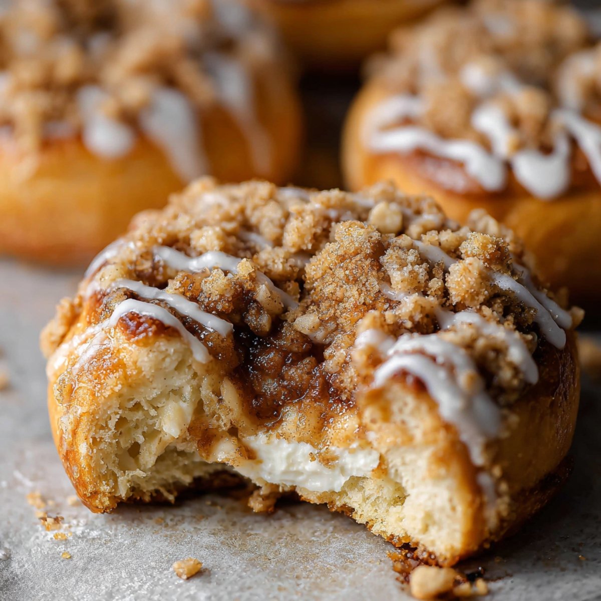 Easy Apple Cheesecake Buns with Streusel Recipe 9 This image shows a close-up of a cinnamon streusel topped Apple Cheesecake Buns with a bite taken out.