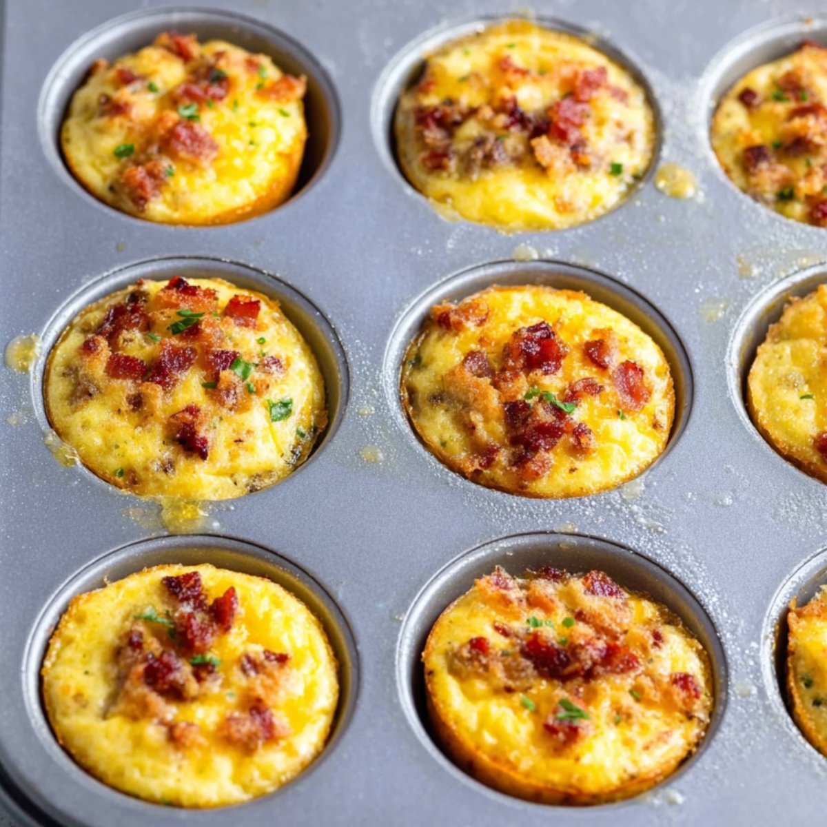 Easy Better Than Starbucks Egg Bites 11 Mini egg muffins with bacon and herbs in a muffin tin, freshly baked