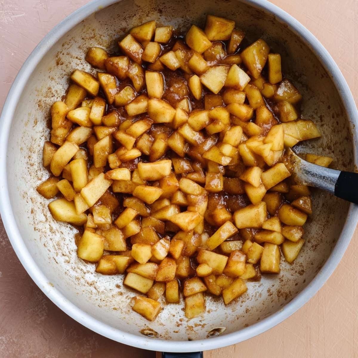 Easy Apple Cheesecake Buns with Streusel Recipe 10 This image shows diced apples cooked in a cinnamon and sugar syrup, creating an apple filling.