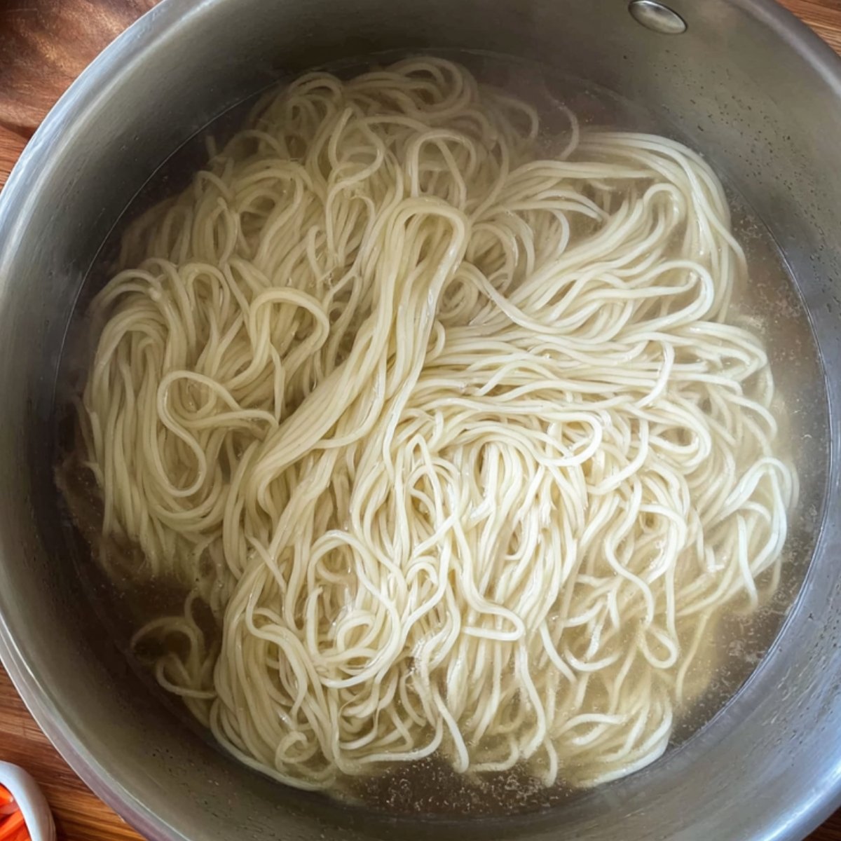 Easy Mongolian Ground Beef Noodles Better Than Takeout 11 The image shows noodles cooking in a pot of boiling water.
