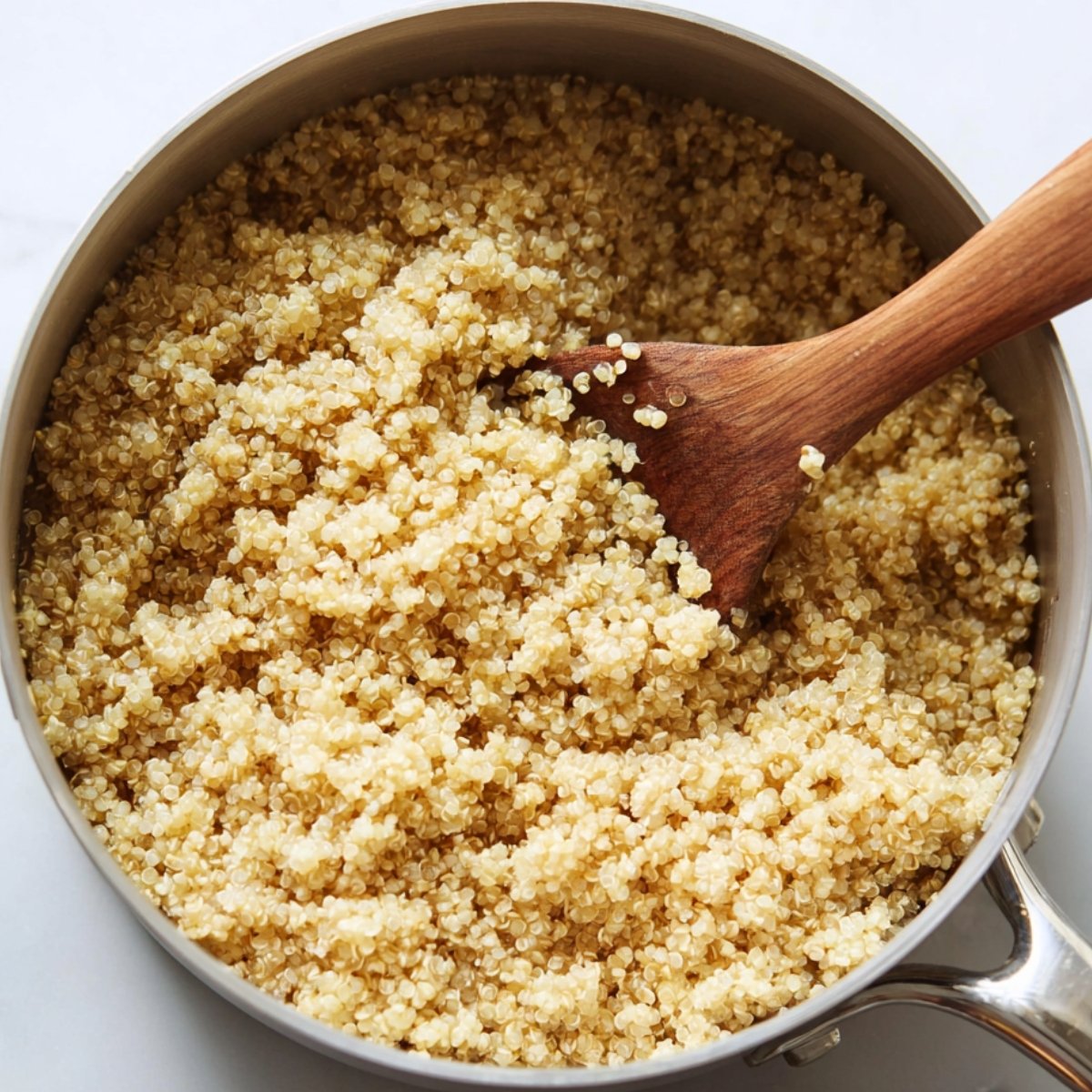 Easy Black Bean Quinoa Salad 10 This image shows a pot of cooked quinoa with a wooden spoon stirring it.