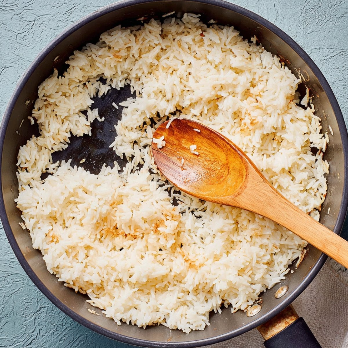 Easy Crispy Salmon Rice Bowls 10 Crispy fried rice in a pan with a wooden spoon.