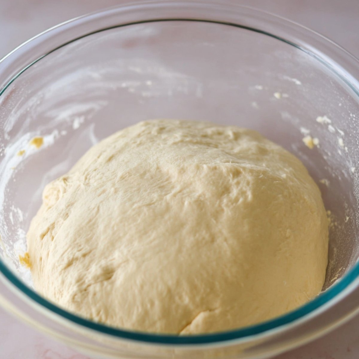 Easy Apple Cheesecake Buns with Streusel Recipe 11 This image shows a smooth dough ball resting in a glass bowl after its first rise.