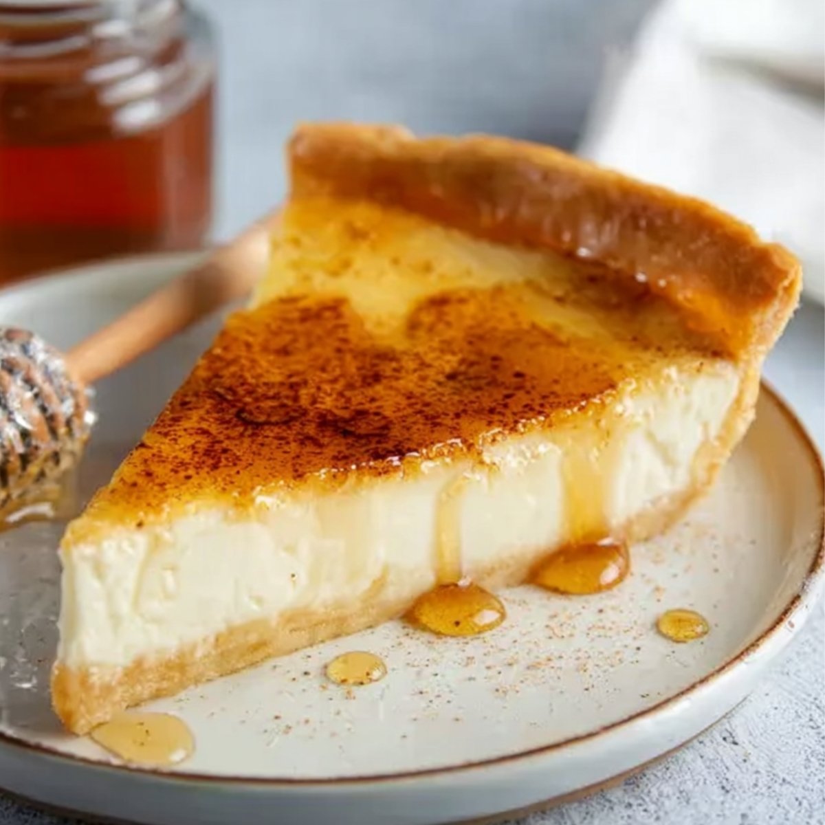 A slice of Greek Honey Pie with a drizzle of honey on top.