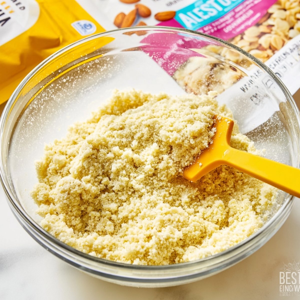 Easy Keto Cheesecake Recipe 10 Almond flour crust mixture in a bowl with a spatula.