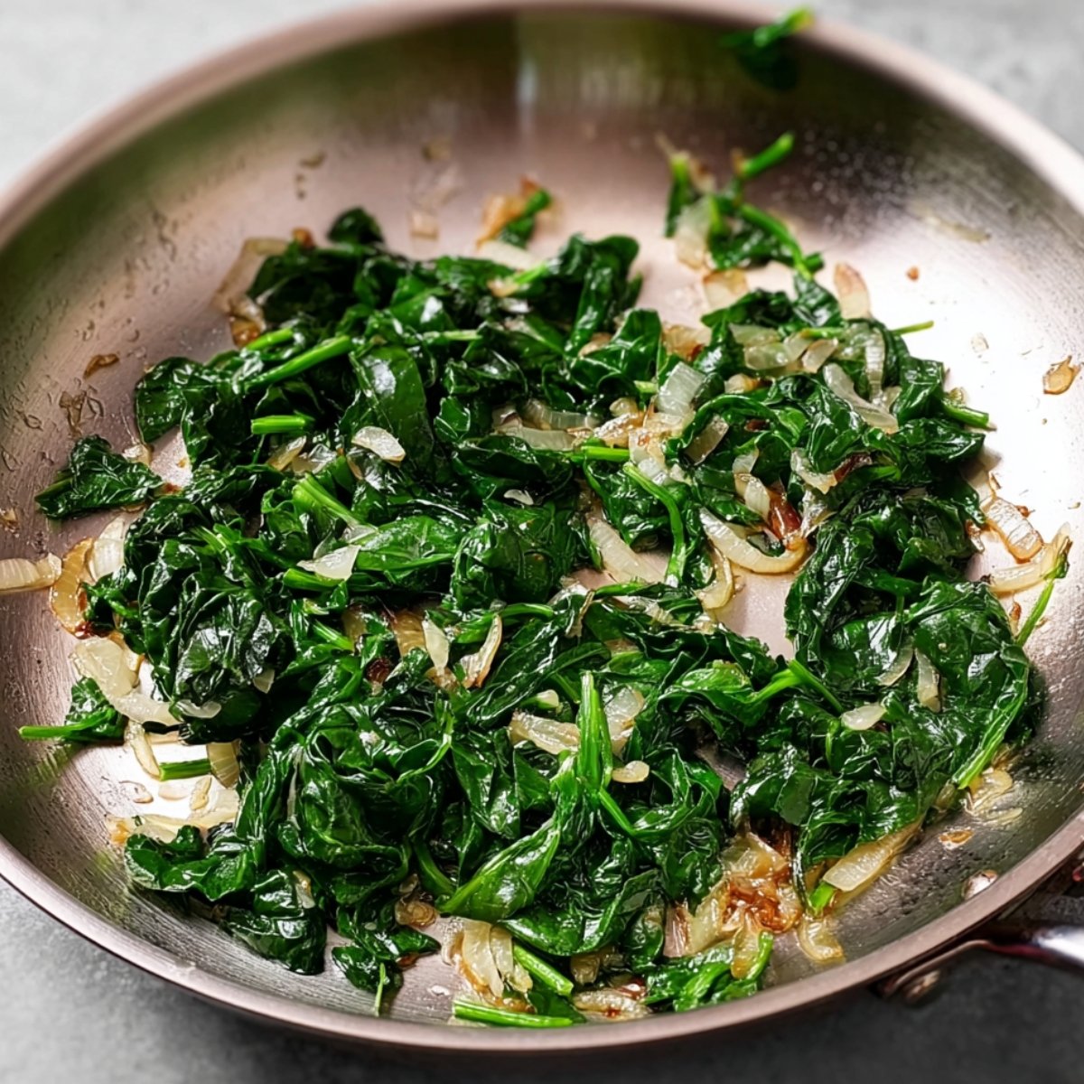 Easy Cranberry Brie Stuffed Chicken Breasts 11 Sautéed spinach and onions in a pan.