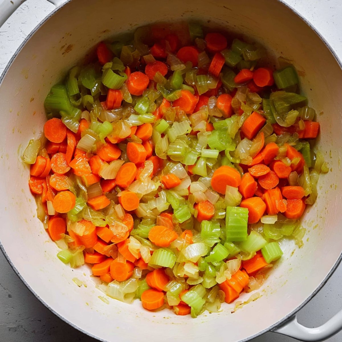 Easy Creamy Vegetable Soup Recipe 10 Sautéed carrots, celery, and onions in a pot.