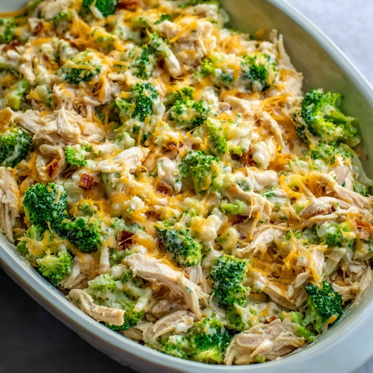 Easy Chicken Bacon Ranch Casserole Recipe 11 This image shows a casserole dish filled with shredded chicken, broccoli, and melted cheese.