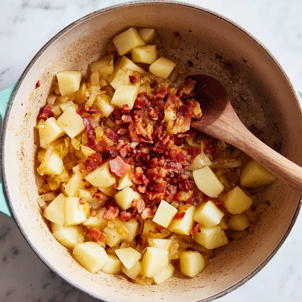 Easy Chicken Potato Soup Recipe 11 Potatoes and bacon in a pot with onions.