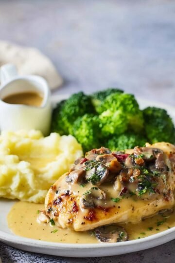 Easy Alice Springs Chicken Recipe 23 Alice Springs Chicken breast with mushroom sauce, mashed potatoes, and broccoli on a plate.