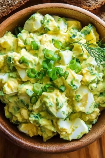 Easy Avocado Egg Salad with Greek Yogurt 1 Bowl of avocado egg salad garnished with green onions and dill