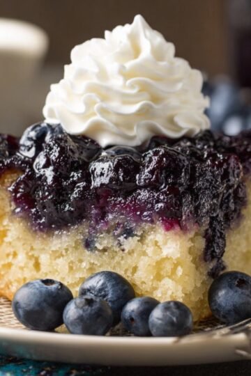 Easy Blueberry Upside Down Cake 3 A slice of Blueberry Upside Down Cake topped with whipped cream and fresh blueberries.