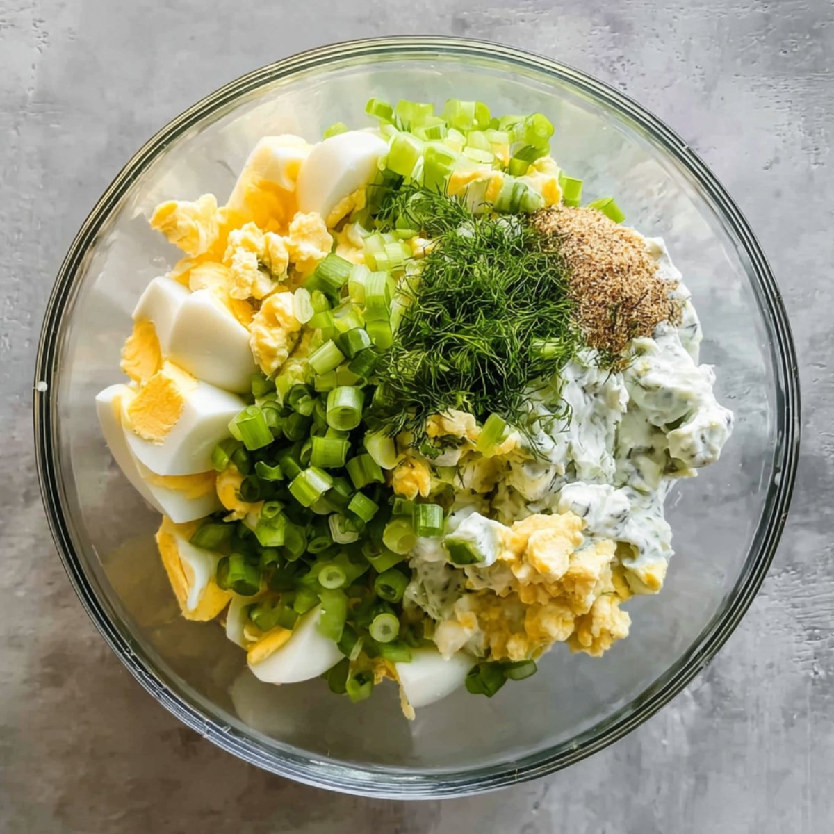 Easy Avocado Egg Salad with Greek Yogurt 11 Bowl with chopped eggs, green onions, and herbs