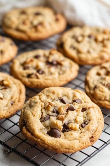 Easy Chocolate Chip Walnut Cookies 15 Freshly baked Chocolate Chip Walnut Cookies on a cooling rack.