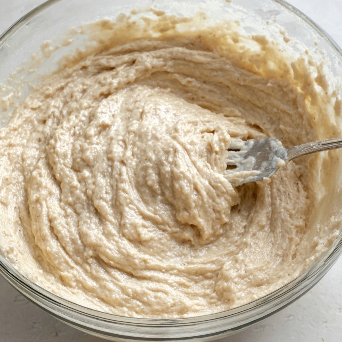 Best Cottage Cheese Pancakes 11 Image of pancake batter being mixed in a bowl with a fork.