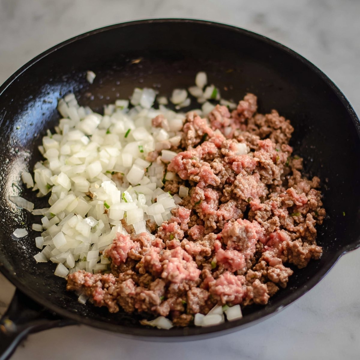 Easy Crispy Ground Beef Tacos 10 Image of ground beef cooking with onions in a skillet.
