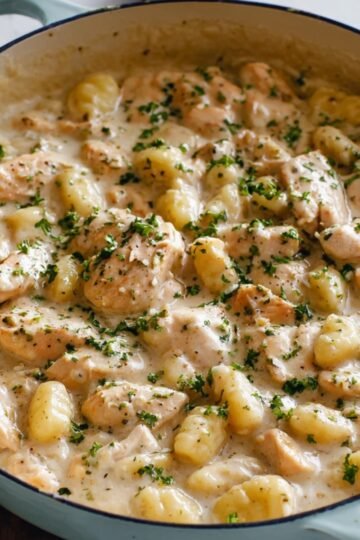 Easy Creamy Garlic Chicken Gnocchi Recipe 9 Creamy Garlic Chicken Gnocchi garnished with herbs.