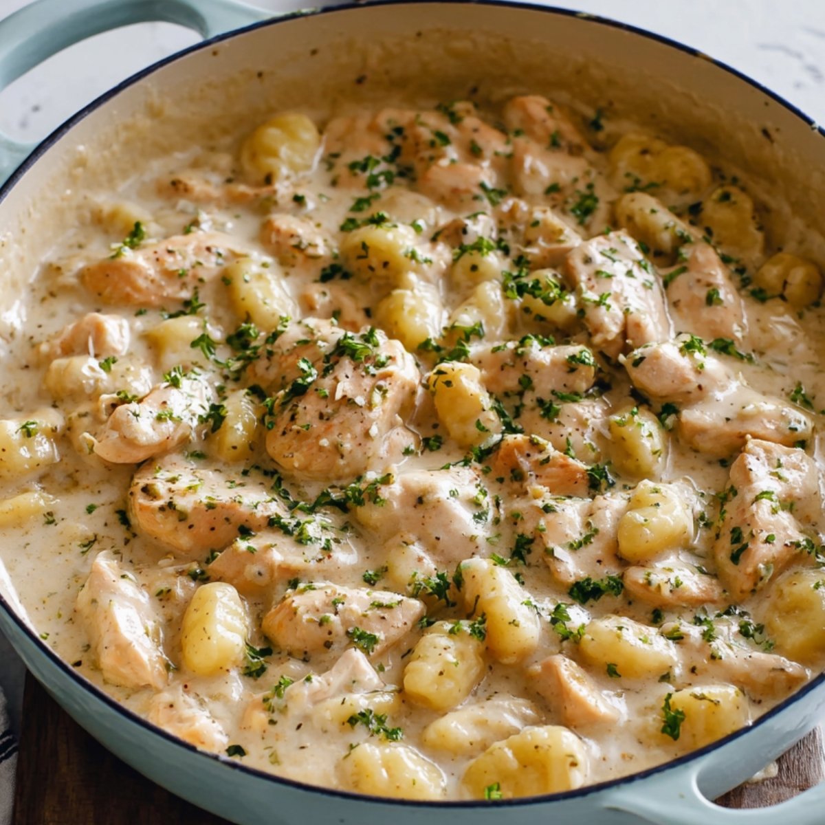 Easy Creamy Garlic Chicken Gnocchi Recipe 9 Creamy Garlic Chicken Gnocchi garnished with herbs.