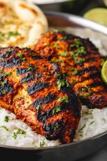 Easy Grilled Tandoori Chicken 1 Grilled Tandoori Chicken served with rice and garnished with lime.