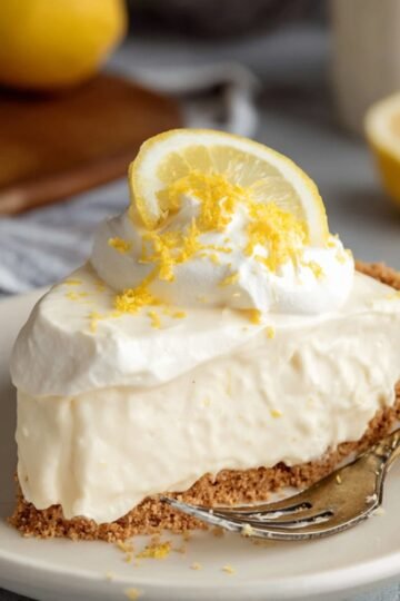 Easy Lemon Cream Pie Recipe 4 Slice of Lemon Cream Pie with whipped topping and lemon garnish.
