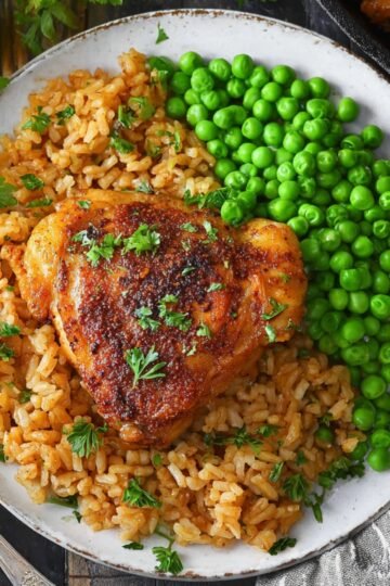 Easy Paprika Chicken and Rice Bake Recipe 2 Paprika Chicken and Rice and green peas on plate.