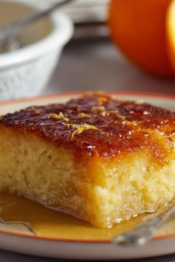 Easy Portokalopita Recipe 13 Slice of Portokalopita Recipe (Greek orange pie) with syrup on a plate.