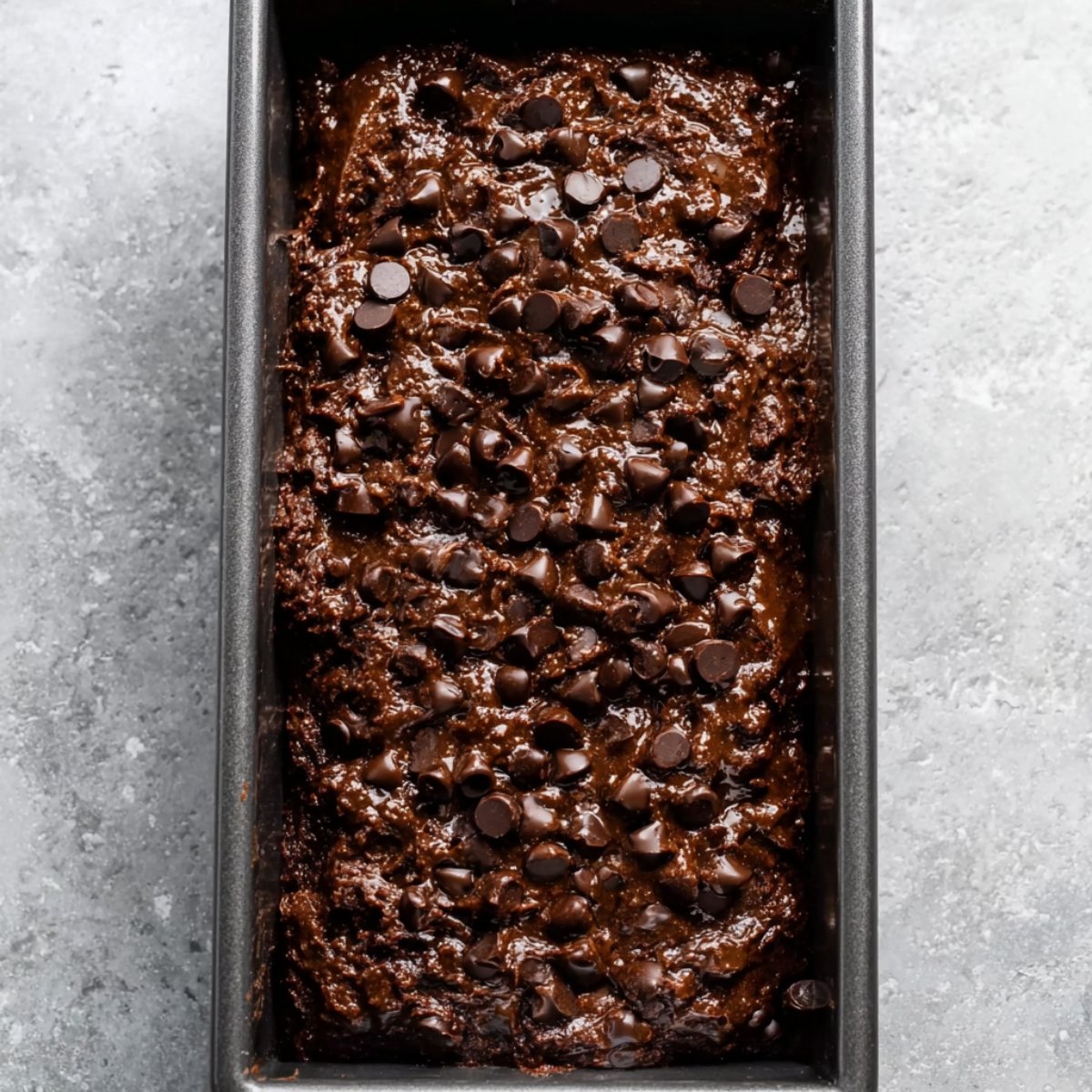 Best Double Chocolate Banana Bread 11 Chocolate banana bread batter in a loaf pan topped with chocolate chips