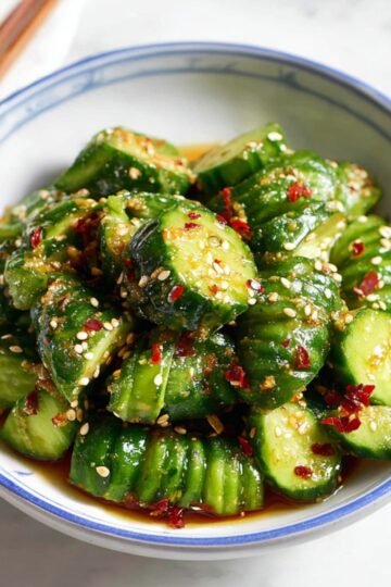Easy Spicy Asian Cucumber Salad Recipe 3 Crispy Spicy Asian Cucumber Salad pieces tossed in spicy Asian dressing with sesame seeds.
