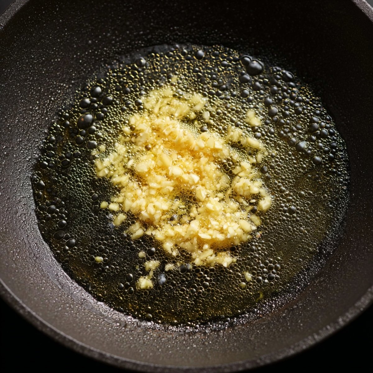 Easy Baked Salmon with Lemon Butter Cream Sauce 11 Minced garlic sizzling in oil in a pan.