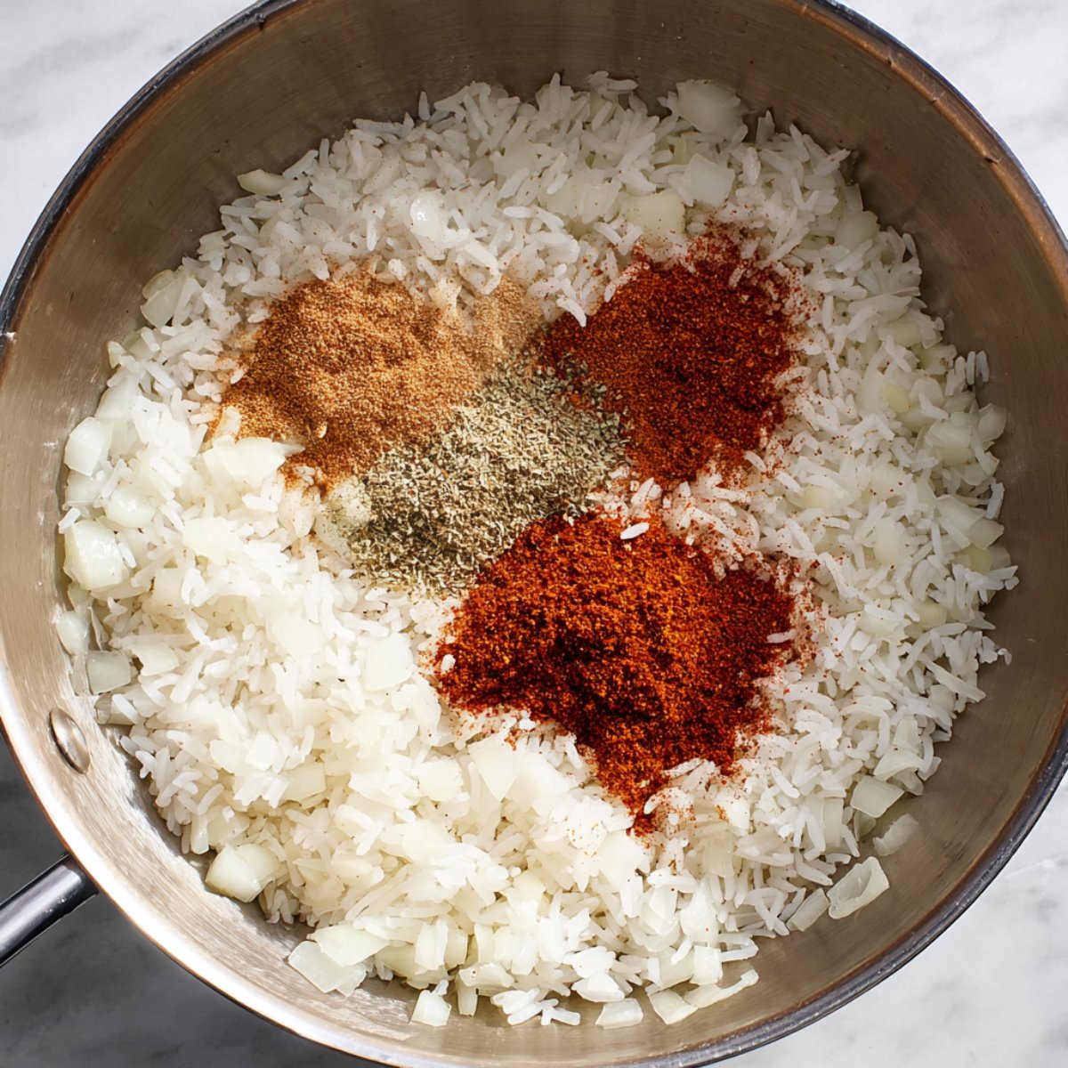 Easy Tomato Rice Recipe 11 Rice and spices in a skillet before cooking.