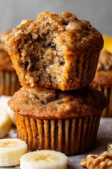 Healthy Banana Muffins Recipe 3 Baked banana muffins with a bite taken out.