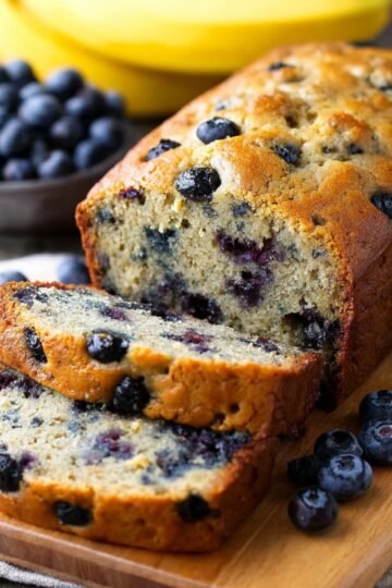 Best Blueberry Banana Bread 19 Sliced blueberry banana bread loaf on a cutting board.