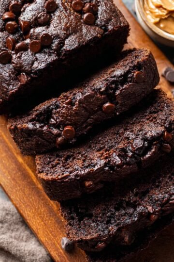 Best Double Chocolate Banana Bread 13 Sliced chocolate banana bread on a wooden board with chocolate chips