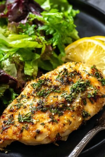 Easy garlic butter baked chicken breasts 8 Baked garlic butter baked chicken breasts with herbs on a plate.